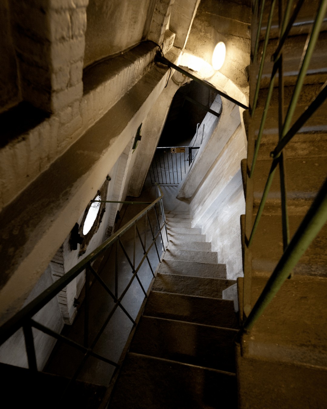 Scalinata in pietra illuminata all'interno della Mole Antonelliana, con travi in legno a vista